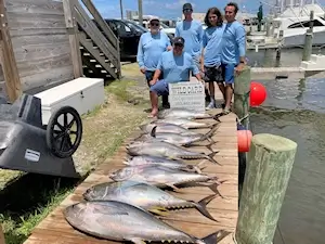 Family group staying in Duck, NC standing with their catch of tuna.