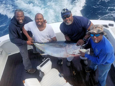 Charter group posing with a really large tuna just caught on an Outer Banks charter.