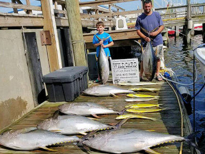 Father and son show off nice offshore fishing catch.
