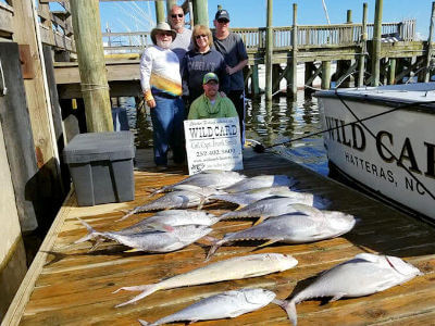 Anglers standing with spectacular catch of tuna on an Outer Banks charter trip.